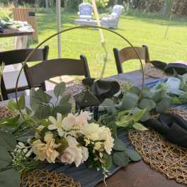 Low floral centerpiece with cream and blush flowers on a table