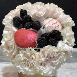 White rose bouquet with blackberries and two decorated macarons in a gold box