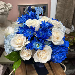 Blue and white bouquet of roses, hydrangeas, and daisies with a ribbon