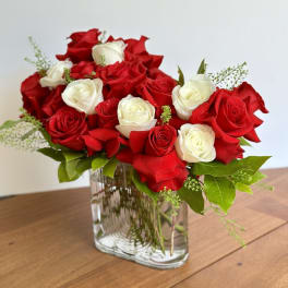 Red and white roses arranged in a clear glass vase