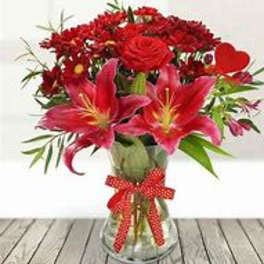 Red flowers in a glass vase with a red ribbon