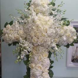 White floral cross arrangement with roses and hydrangeas