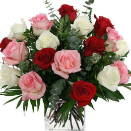 Bouquet of red, pink, and white roses in a clear glass vase