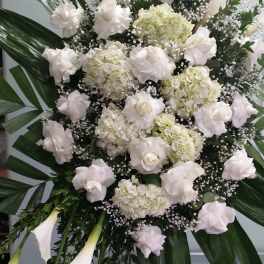 Large white floral standing spray with roses, hydrangeas, and calla lilies