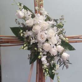 White floral spray on a bamboo stand with pink ribbons