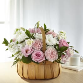 Pink and white flower basket in a wooden handled container
