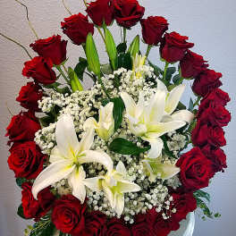 Red roses and white lilies arranged in a white vase