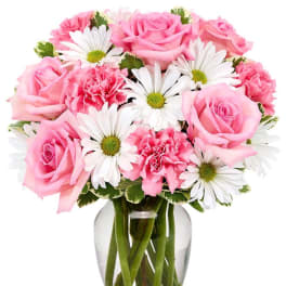 Pink roses and carnations with white daisies in a glass vase