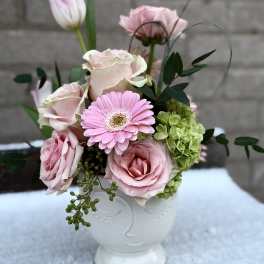 Pink roses and a gerbera daisy in a white vase