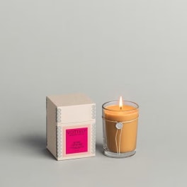 Lit candle beside its boxed packaging