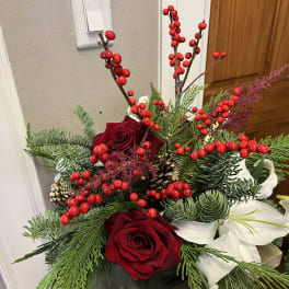 Holiday arrangement with red roses, white amaryllis, and red berries