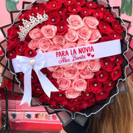 Heart-shaped bouquet of red and pink roses with a tiara and ribbon