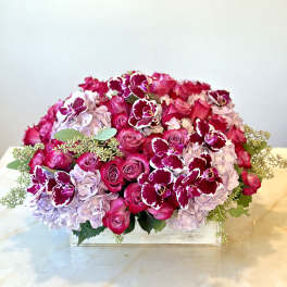 Pink roses and lavender hydrangeas with burgundy orchids in a low wooden box