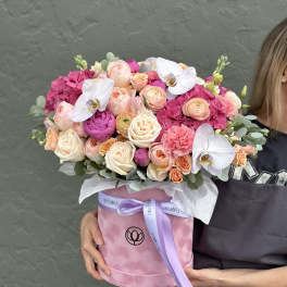 Pink and peach bouquet in a round box with white orchids