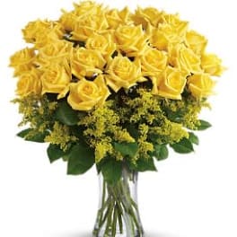 Tall clear glass vase filled with many yellow roses and yellow filler flowers
