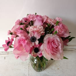 Pink roses and carnations in a clear glass vase