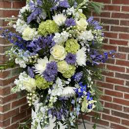 Tall standing floral spray with purple, white, and green blooms