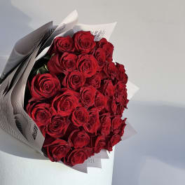 Bouquet of red roses wrapped in white paper