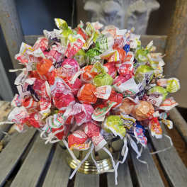 Bouquet of colorful wrapped candies in a gold vase