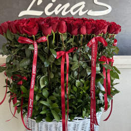 Large basket arrangement of red roses with red ribbons