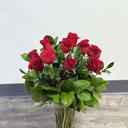 Red roses arranged in a clear glass vase