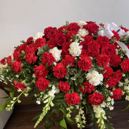 Large red and white floral casket spray with ribbon