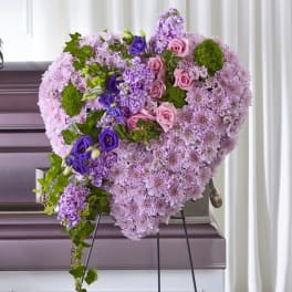 Heart-shaped floral spray with pink and purple flowers on an easel