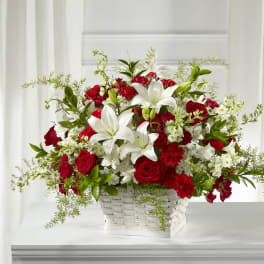 Red roses and white lilies arranged in a white basket