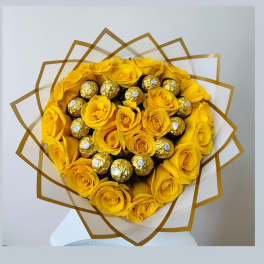 Yellow rose bouquet with gold-wrapped chocolates in a decorative wrap