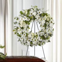 White floral wreath on a black easel