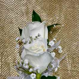 White rose boutonniere with baby's breath and ribbon on a gold background