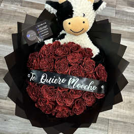 Red glitter rose bouquet with a plush cow and a black ribbon banner