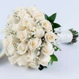 Hand-tied bouquet of white roses and baby's breath wrapped in white ribbon