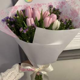 Bouquet of pink and white tulips with purple filler flowers in white wrap