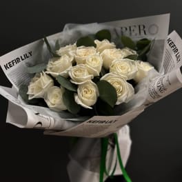 Bouquet of white roses wrapped in printed paper
