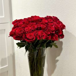Large bouquet of red roses in a tall clear glass vase