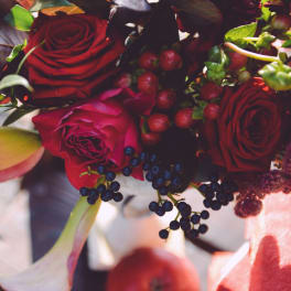 Bouquet of red roses, calla lilies, and berries