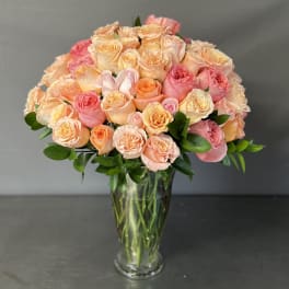 Bouquet of peach and pink roses in a clear glass vase