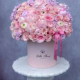 Pink rose and hydrangea arrangement in a round hat box with ribbon