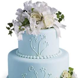Two-tier blue cake with white floral decorations and roses