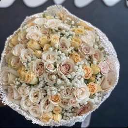 Round bouquet of cream and blush roses with white filler flowers