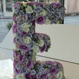 Large floral letter "F" covered in pastel roses