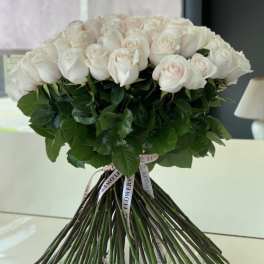 Bouquet of pale pink and white roses tied with ribbon