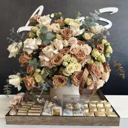 Large bouquet of cream and blush roses with eucalyptus in a white box, with chocolates below