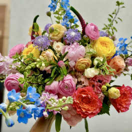 Colorful bouquet with pink, yellow, blue, and coral flowers