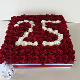 Rectangular box arrangement of red and white roses with a ribbon bow