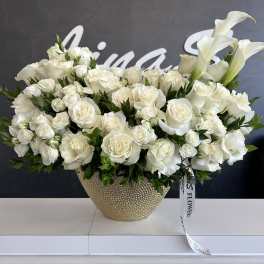 White roses and calla lilies in a gold textured vase