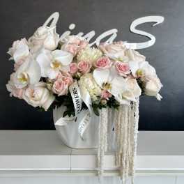 White and blush bouquet of roses and orchids in a white vase