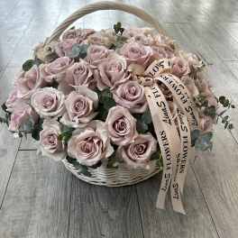 Basket of pale pink roses with eucalyptus and ribbon