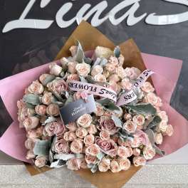 Large bouquet of pale pink roses wrapped in pink and brown paper